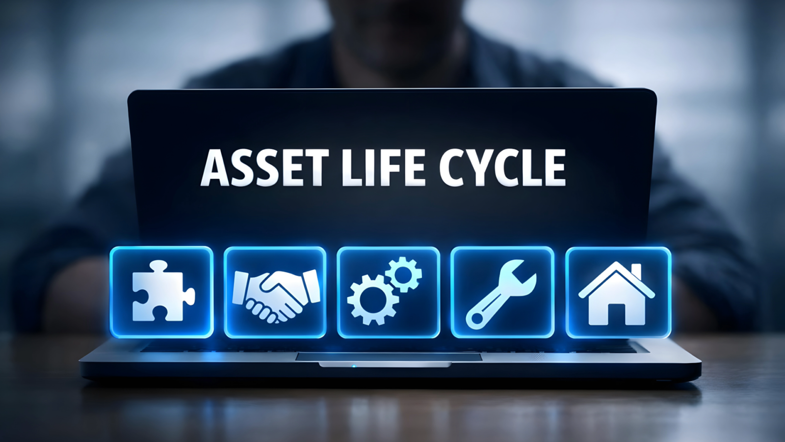 The words Asset LifeCycle on the back of a laptop computer with the silhouette of a person viewing the screen. Icons showing a puzzle piece, shaking hands, cogs, a spanner and a house are also shown